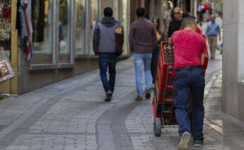 Un hombre reparte bebidas este martes en Toledo. EFE.