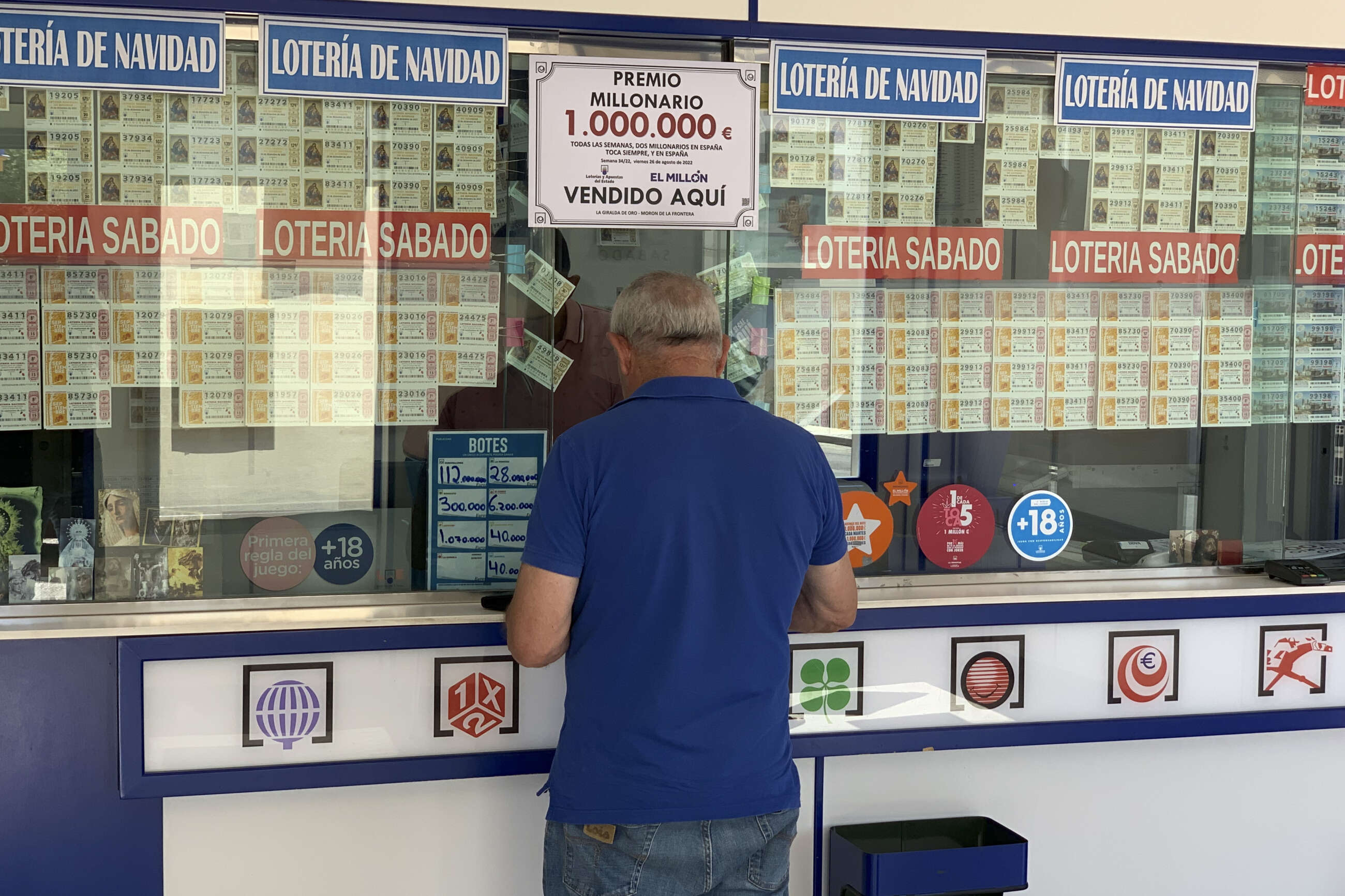 Un hombre adquiere un boleto de Lotería en la administración de 'La Giralda de Oro', en Morón de la Frontera (Sevilla). EFE/Fermín Cabanillas