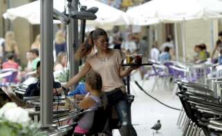 Una camarera reparte una consumición en una terraza. EFE/Javier Etxezarreta