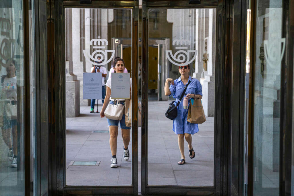 MADRID, 13/07/2023.- Varias personas llegan a una oficina de Correos de Madrid, este jueves, último día para pedir el voto por correo.  Correos abrirá todas las oficinas de la ciudad de Madrid y Barcelona así como las de los destinos más turísticos para facilitar la entrega de la documentación del voto por correo y su emisión, cuyo plazo finaliza el 20 de julio. EFE/ Daniel González