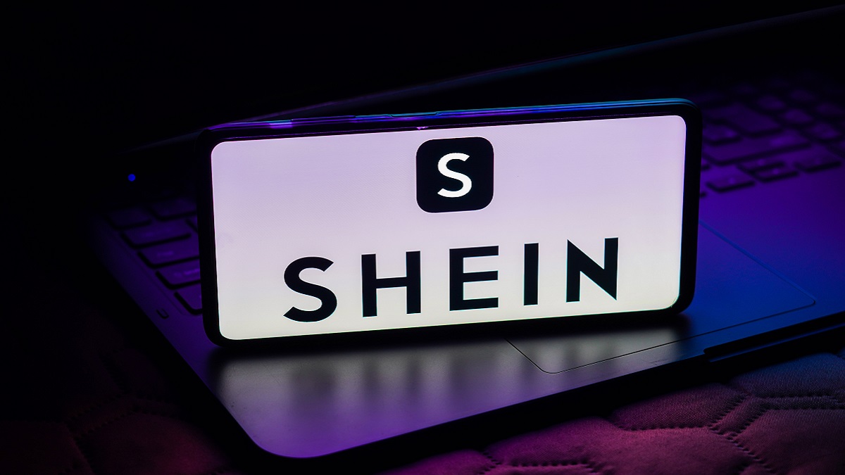 Un móvil sobre un ordenador con el logo de Shein en la pantalla