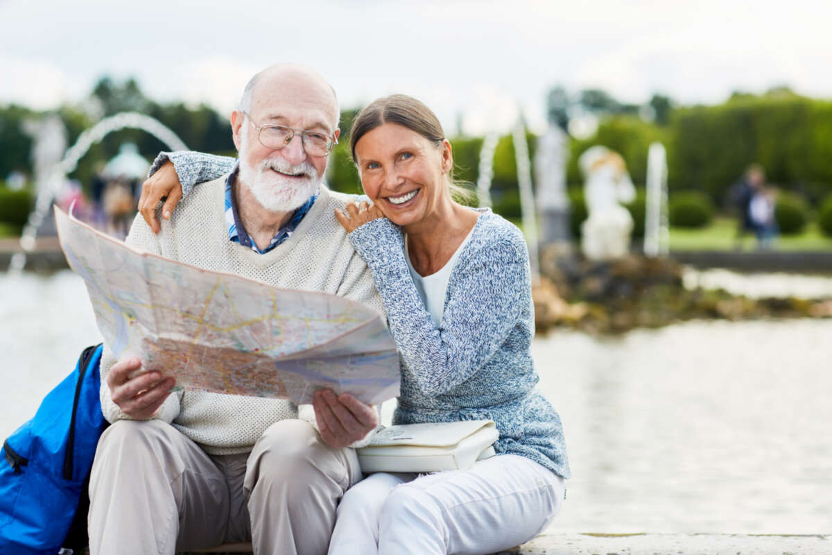 Dos personas mayores consultan un mapa mientras están de vacaciones. Foto: Freepik.