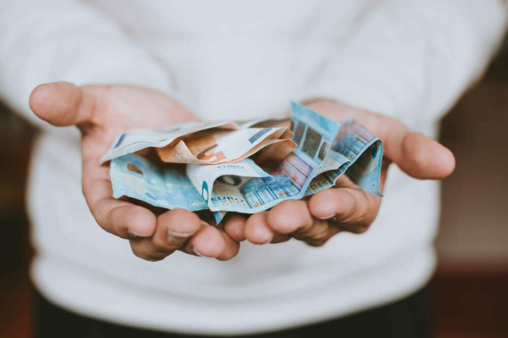 Persona sosteniendo billetes de euro. Unsplash MOROSIDAD BANCA