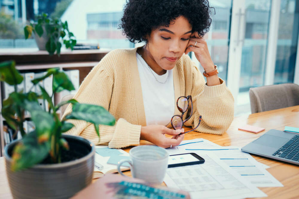 Una mujer piensa cuál es la mejor opción si una cuenta ahorro o una cuenta remunerada