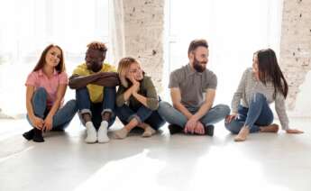 Un grupo de jóvenes conversan sentados en el suelo. Foto: Freepik.