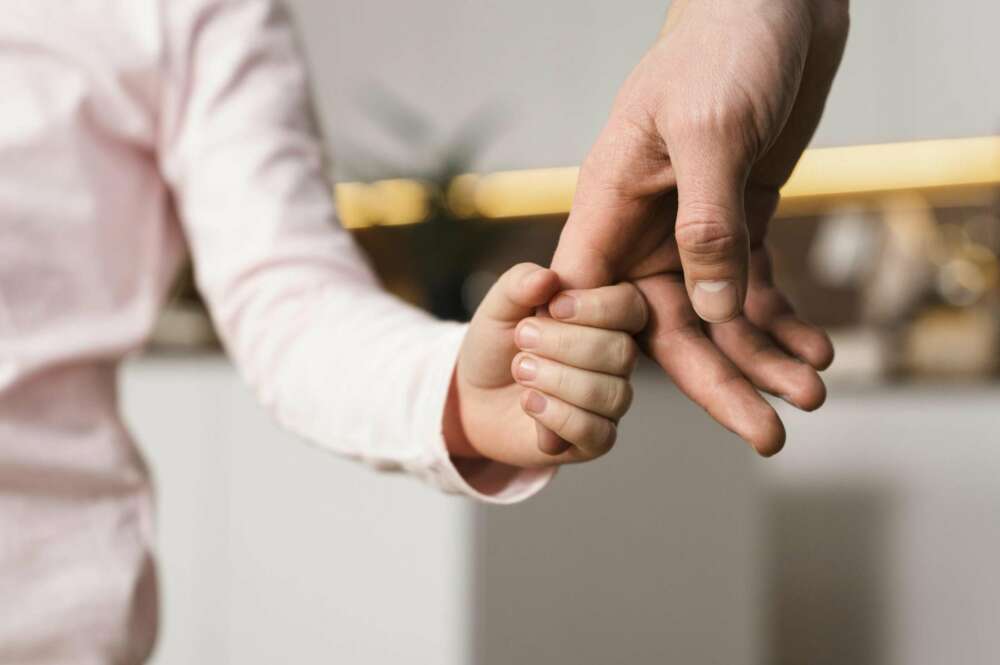 Padre e hija cogidos de la mano.