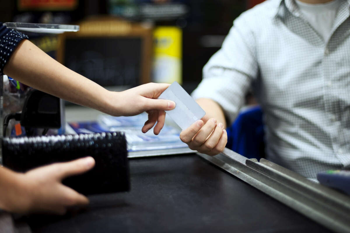 Una mujer pagando con tarjeta en un establecimiento.