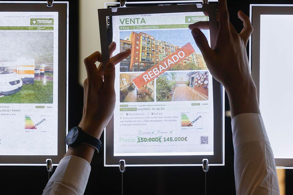 Un trabajador coloca un cartel en una inmobiliaria. Foto: EFE.