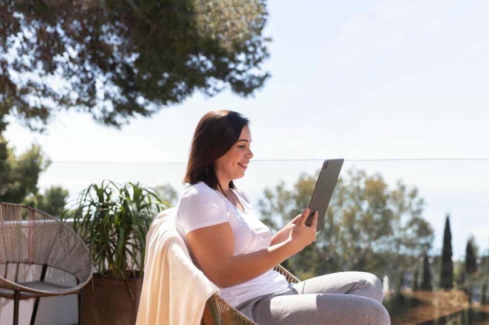 Una mujer utiliza una tablet en una zona rural. Foto: Freepik.