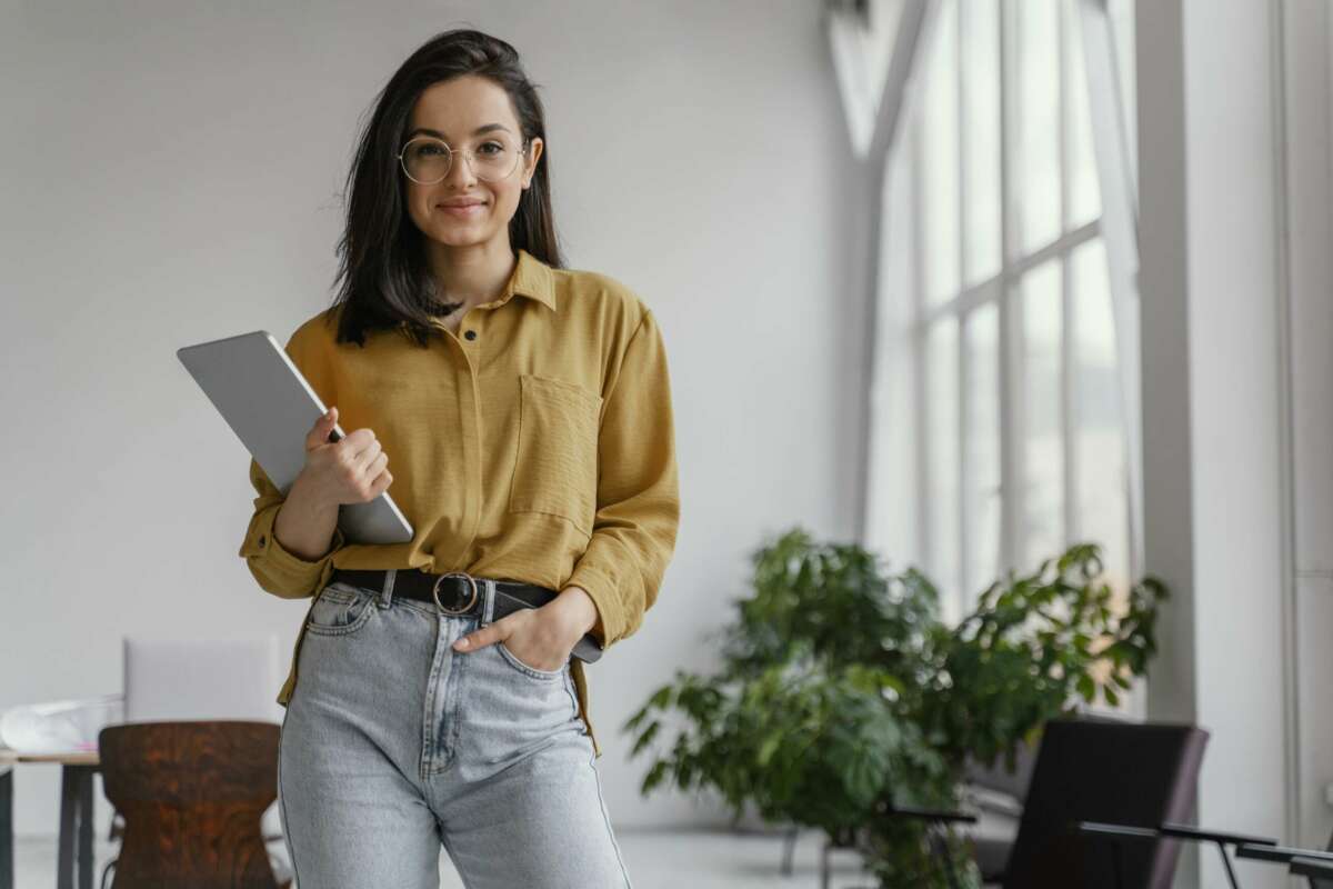 Una mujer emprendedora posa con su ordenador portátil. Ayudas. Foto: Freepik.