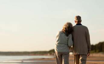 Una pareja de jubilados camina por la playa. pensión. Foto: Freepik.