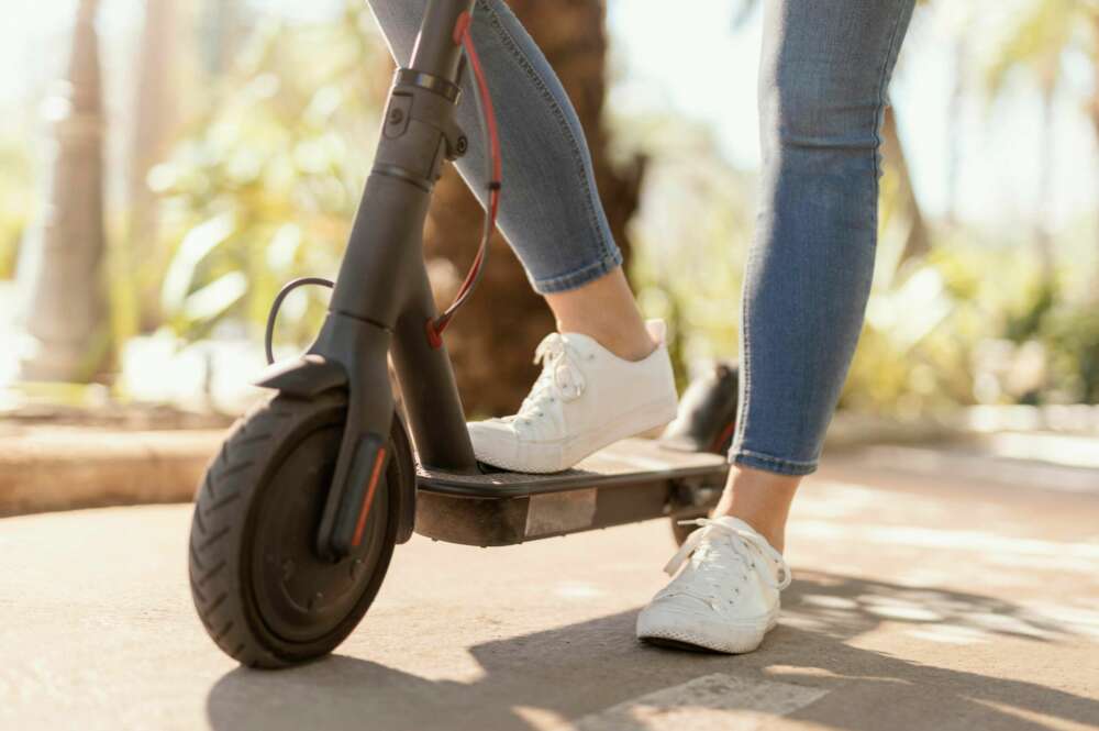 Una mujer conduce un patinete eléctrico. Foto: Freepik.