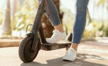 Una mujer conduce un patinete eléctrico. Foto: Freepik.