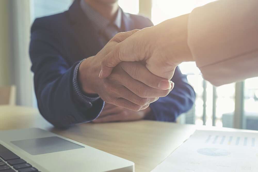 Dos personas de una empresa estrechan sus manos en un acuerdo