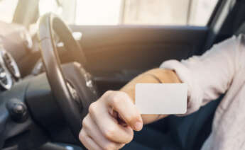 Una persona enseña su carnet de conducir.