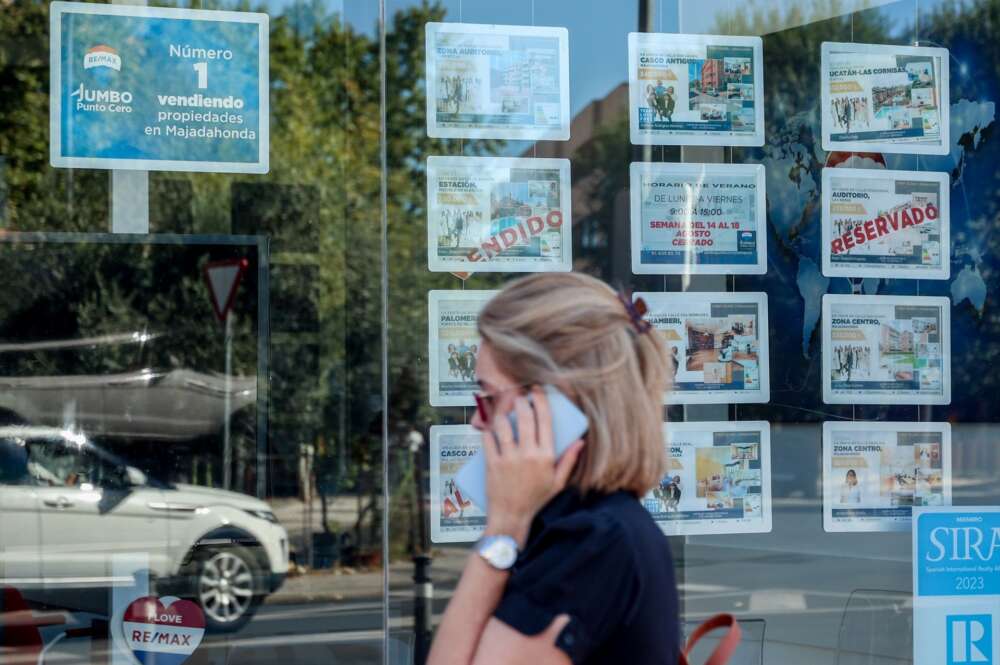 Una mujer camina frente a un escaparate de anuncios de viviendas en Madrid (España). Foto: Ricardo Rubio/Europa Press