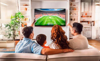 Familia viendo un partido de fútbol en el televisor de su casa