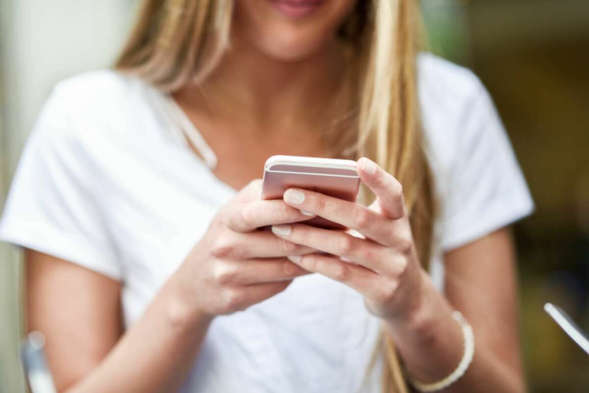 Una mujer recibe un mensaje en su teléfono móvil. Foto: Freepik.