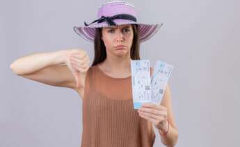 Una mujer enfadada posa con sus billetes de avión. aerolínea. Foto: Freepik.