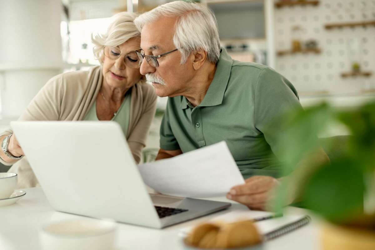 Dos jubilados consultan un documento en su ordenador. pensión. Foto: Freepik.