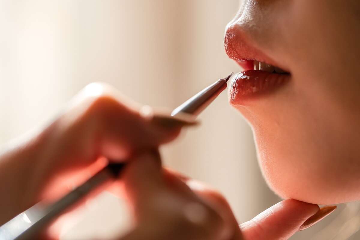 Una chica pintando sus labios