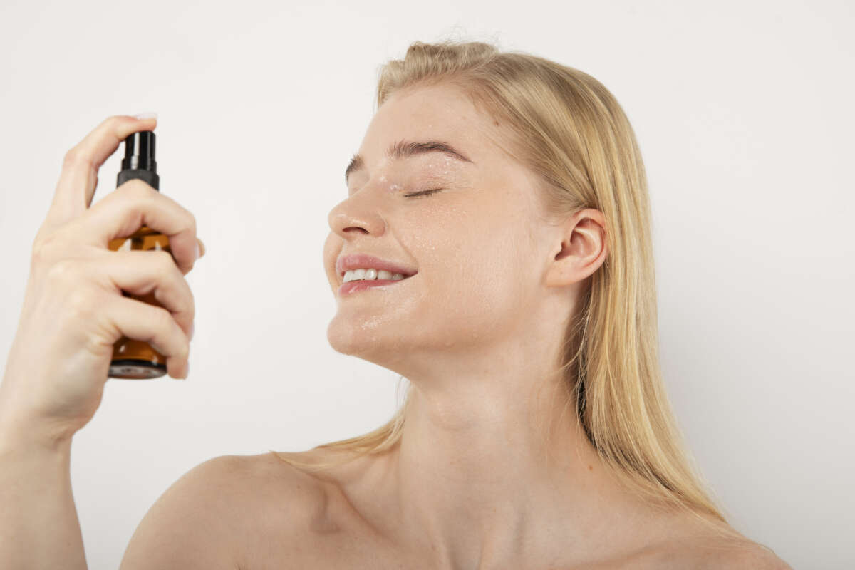 Una chica utilizando un spray fijador de maquillaje