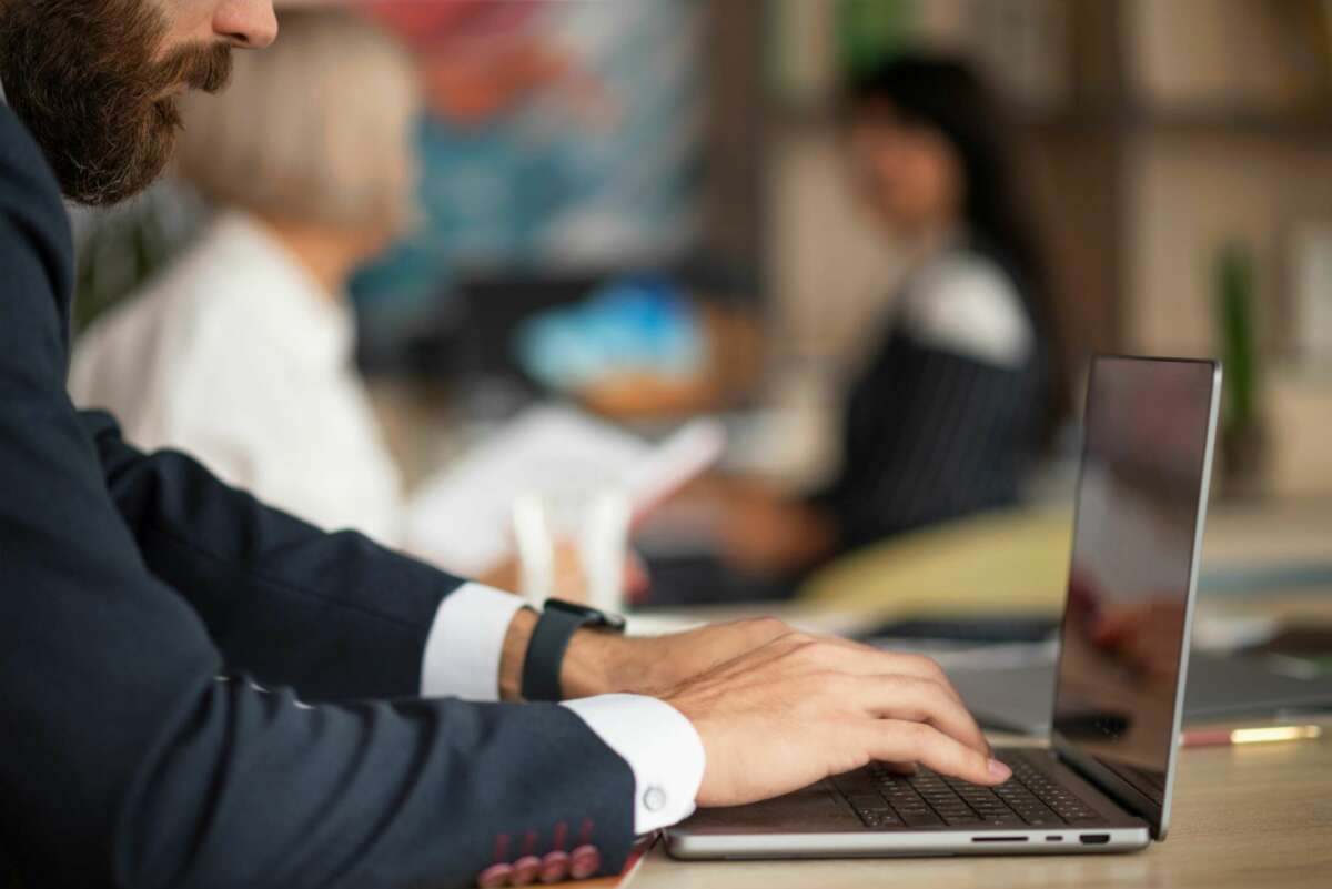 Un trabajador consulta su ordenador en la oficina. Hipoteca. Foto: Freepik.