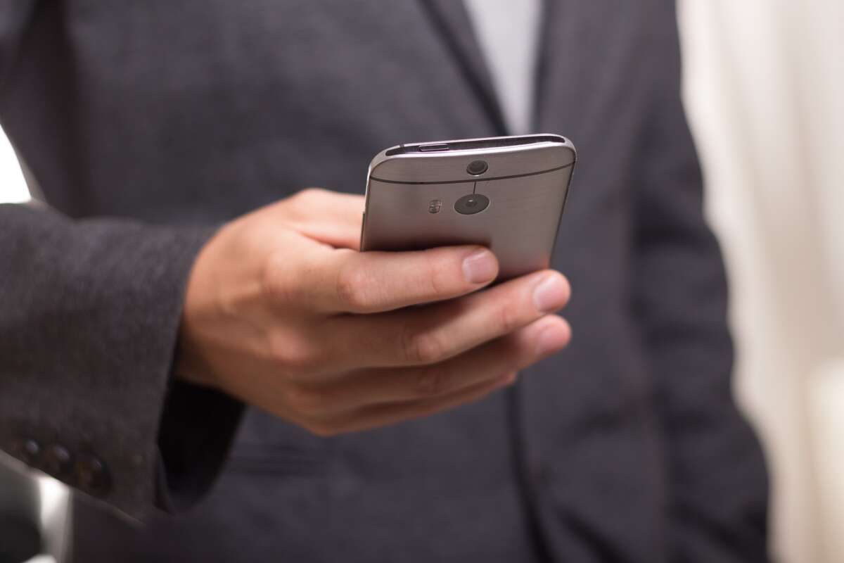 Un hombre utiliza su teléfono móvil. Caixabank. Foto: Pixabay.