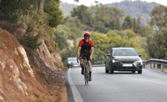 Un hombre conduce su bicicleta por la carretera. Foto: Freepik.