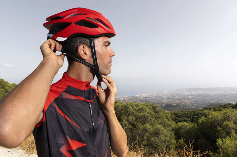 Un hombre se ata el casco para circular en bicicleta. DGT. Foto: Freepik.