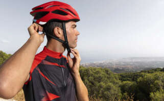 Un hombre se ata el casco para circular en bicicleta. DGT. Foto: Freepik.