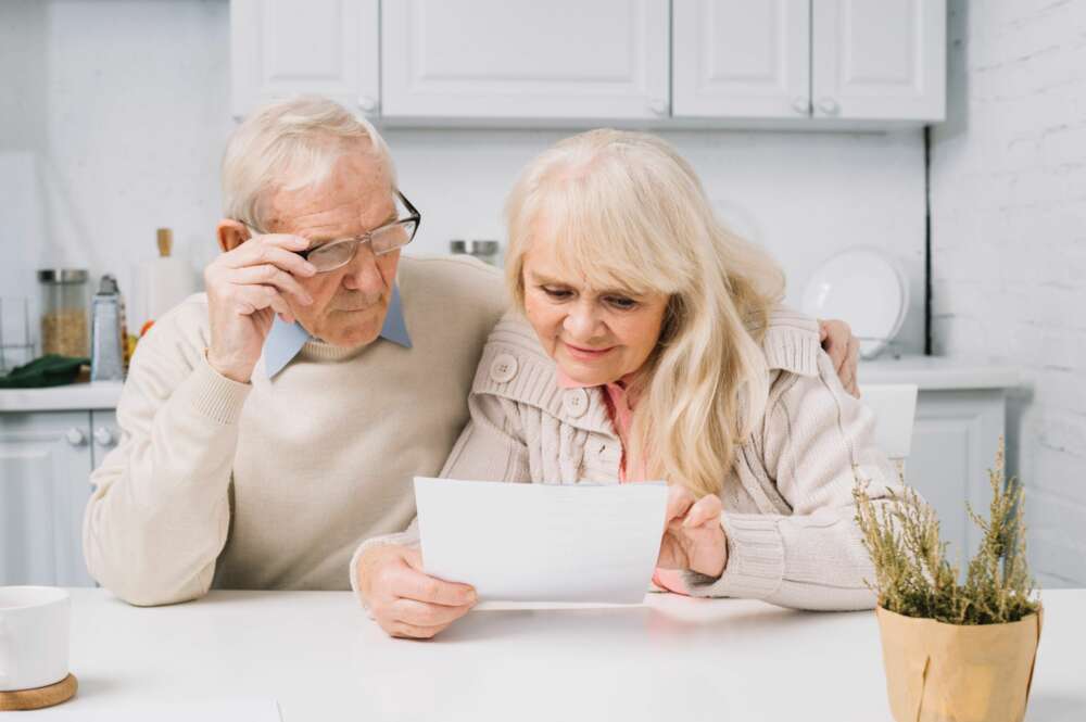 Unos abuelos consultan un documento. jubilación.