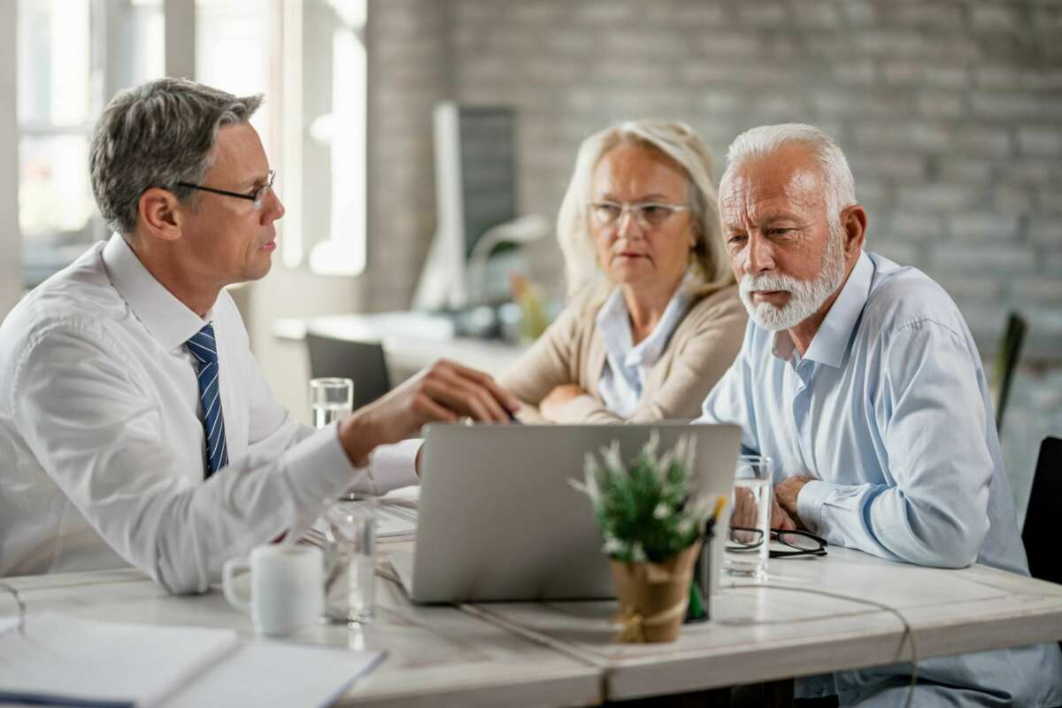 Un par de jubilados comentan con su gestor la contratación de un plan de pensiones. Jubilación. Foto: Freepik.