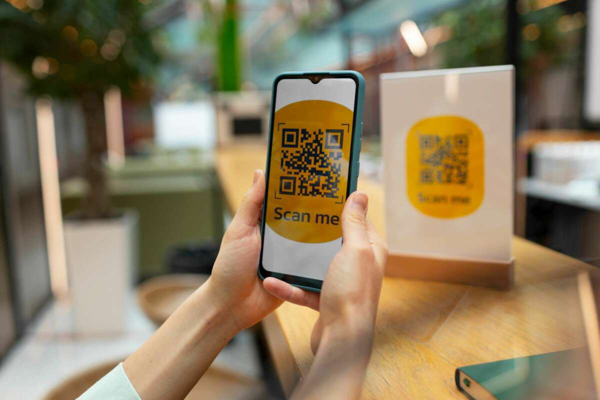 Una mujer escanea una código QR-. EVO Banco. Foto: Freepik.