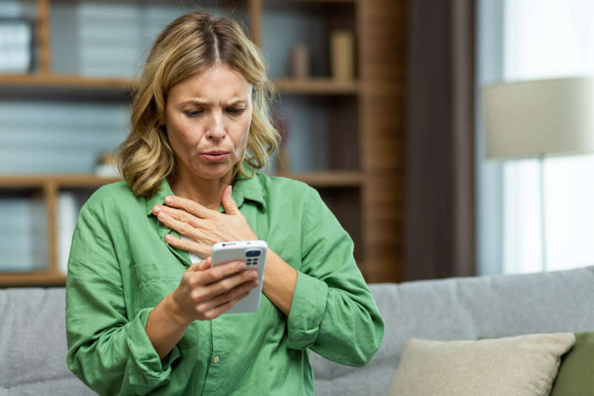 Una mujer se sorprende al leer un mensaje en su teléfono móvil. Banco Santander. Foto: Envato.