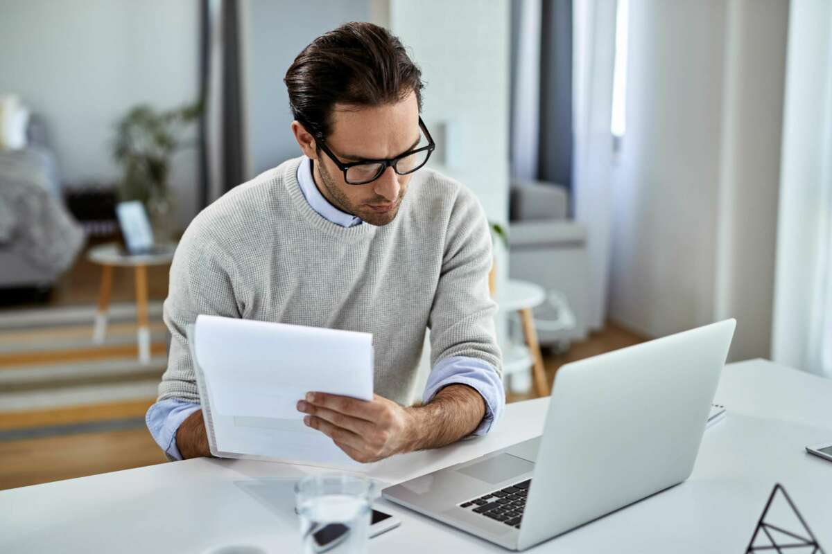 Un hombre consulta unas facturas. Caixabank. Foto: Freepik.