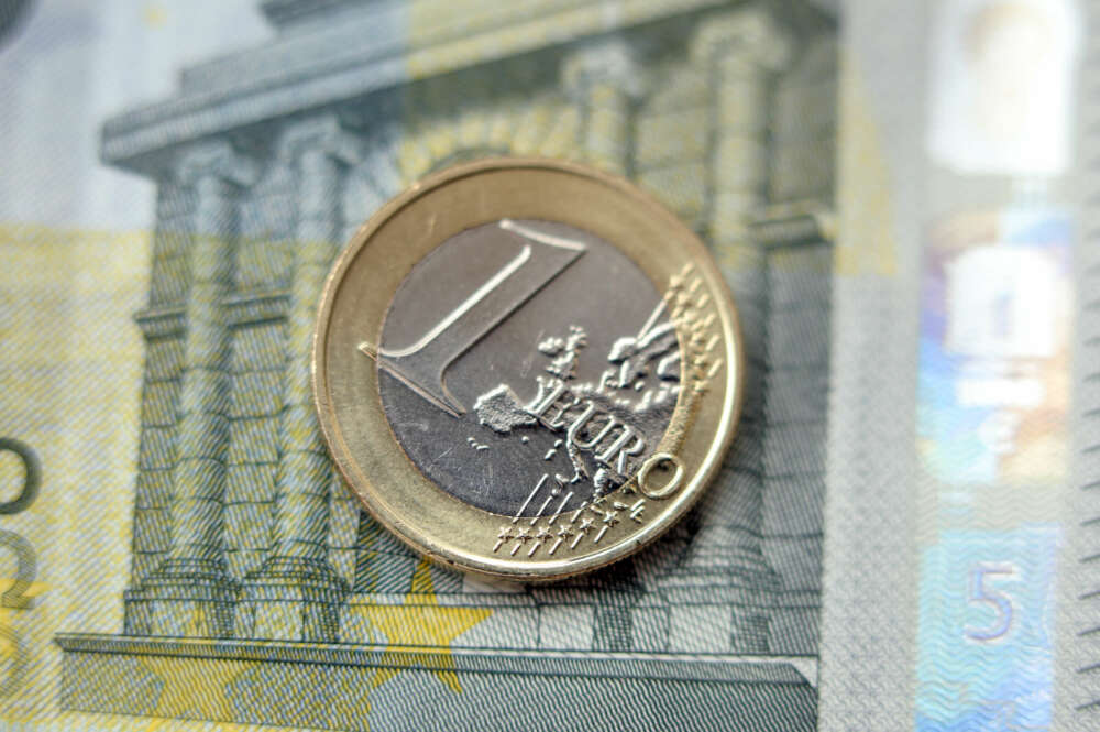 moneda de 1 euro sobre un billete de 5 euros