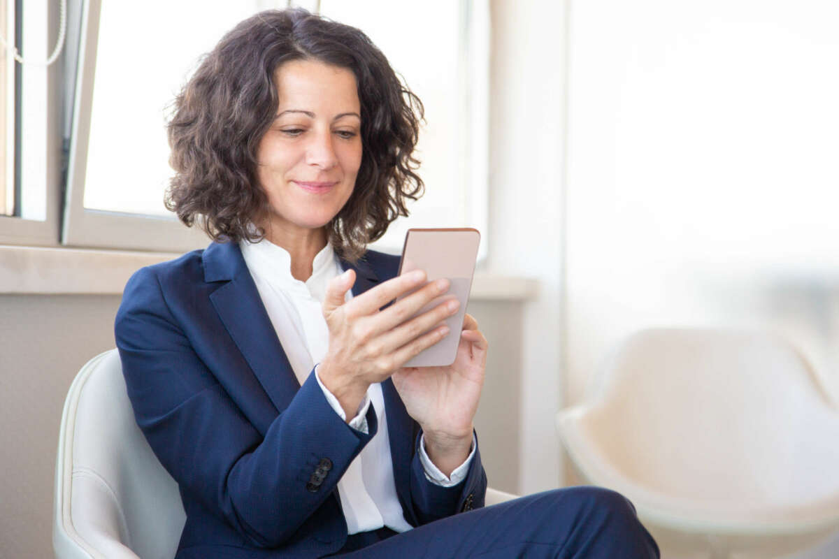 Mujer mirando sus planes de Unicaja a través del móvil 