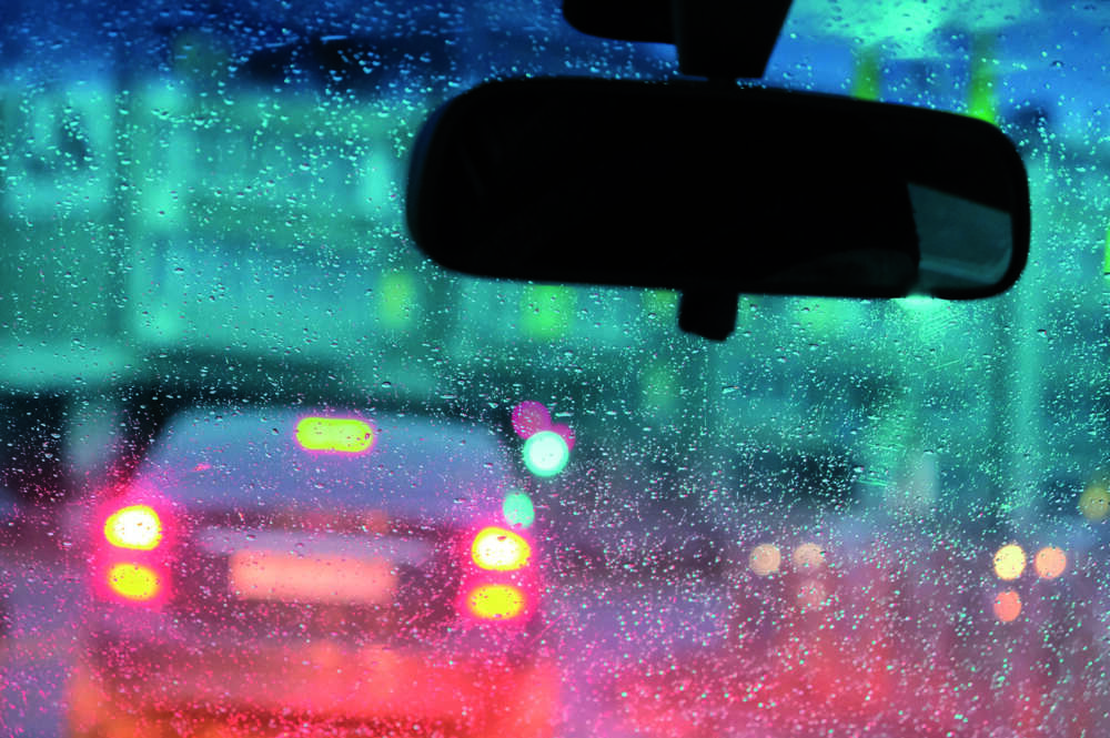 Un coche circula bajo la lluvia.