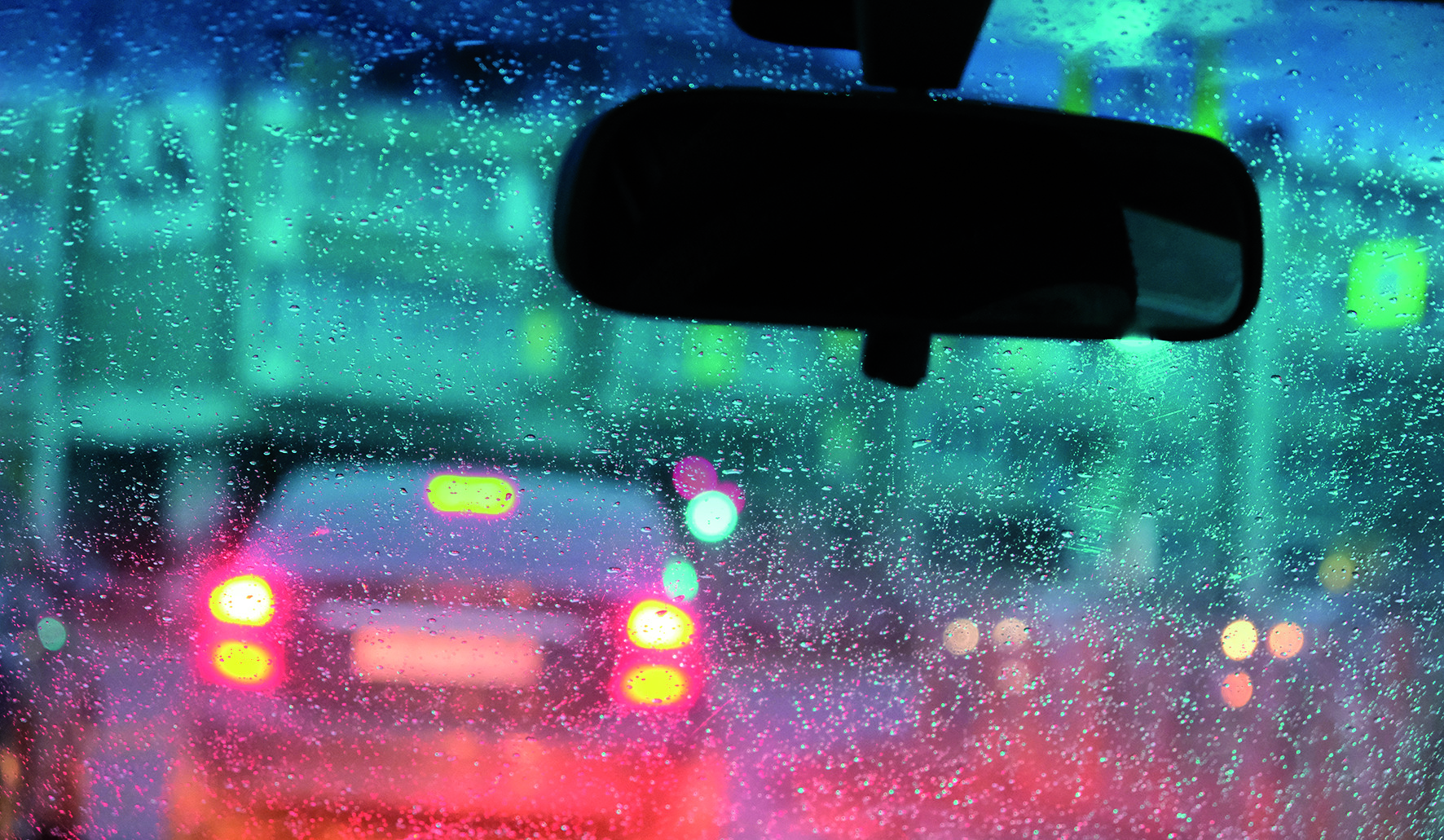 Un coche circula bajo la lluvia.