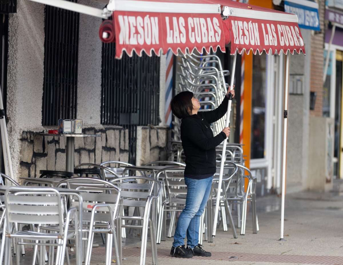 (Foto de ARCHIVO) Una camarera levanta el toldo de un bar, a 12 de enero de 2024, en Madrid (España). El Ministerio de Trabajo ha acordado este viernes con CCOO y UGT subir el salario mínimo interprofesional (SMI) para 2024 un 5%, desde los 1.080 euros mensuales por catorce pagas hasta los 1.134 euros. Esta subida se aplica con efectos retroactivos desde el 1 de enero de 2024. Las organizaciones empresariales CEOE y Cepyme no se han sumado al acuerdo porque no se han atendido sus demandas de indexar el SMI a los contratos públicos. Eduardo Parra / Europa Press 12 ENERO 2024;SMI;SALARIO MINIMO;SALARIO MÍNIMO INTERPROFESIONAL 12/1/2024