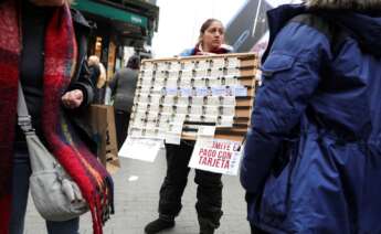 Una mujer vendiendo décimos de la Lotería de Navidad