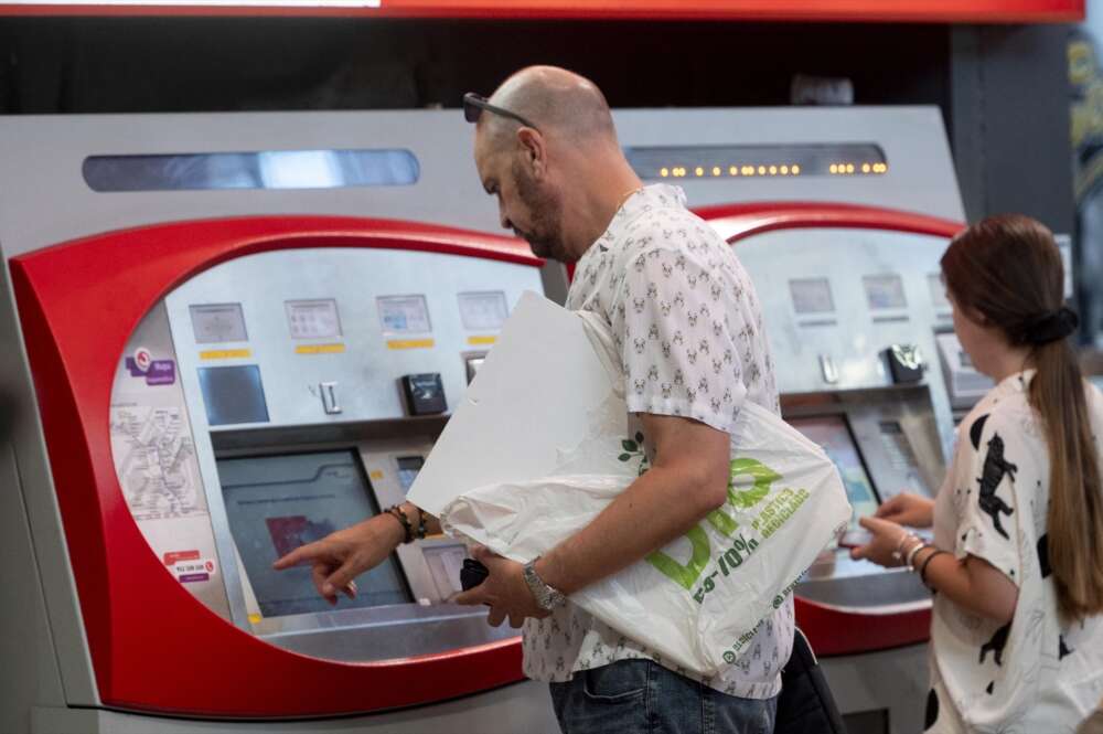 Una persona saca un billete de Renfe.