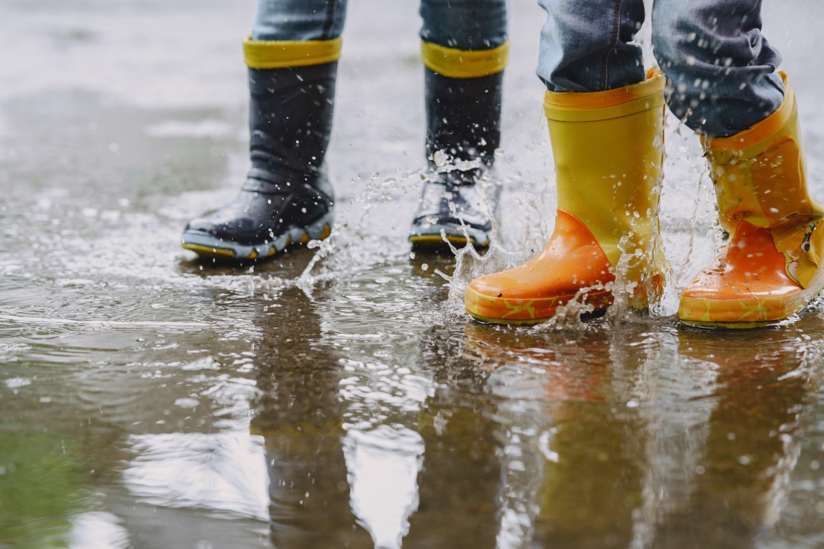 Unos niños jugando con sus botas de agua