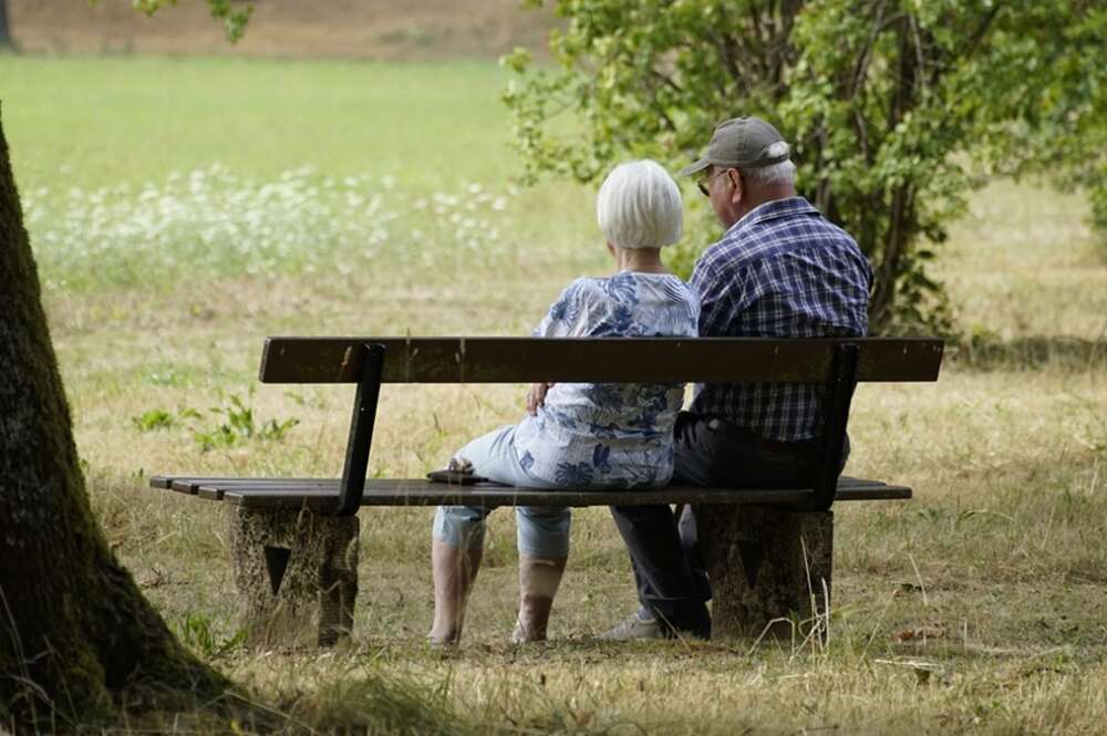 Una pareja de jubilados sentados en un banco