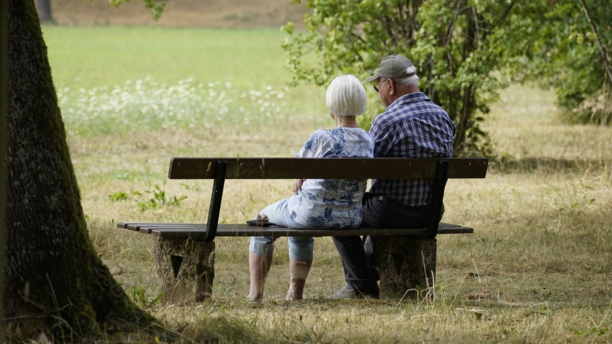 Una pareja de jubilados sentados en un banco