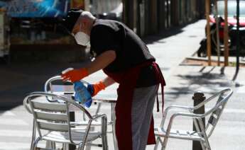 Un camarero limpia las mesas y sillas de una terraza de un bar - Iván Terrón - Europa Press - Archivo