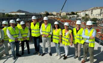 Personas con chaleco verde y casco en una construcción ferroviaria en Alicante