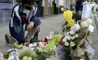 Un joven se arrodilla ante el altar colocado en la acera donde fue golpeado Samuel, el joven asesinado en A Coruña el pasado sábado 3 de julio, a 6 de julio de 2021, en A Coruña, Galicia, (España). Familiares, amigos, y vecinos han organizado este altar c - M. Dylan