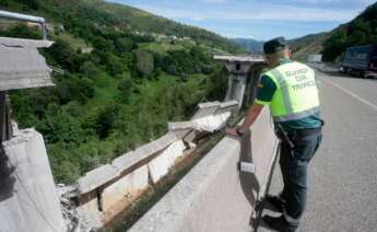 Un agente de la Guardia Civil en la parte del puente derrumbado